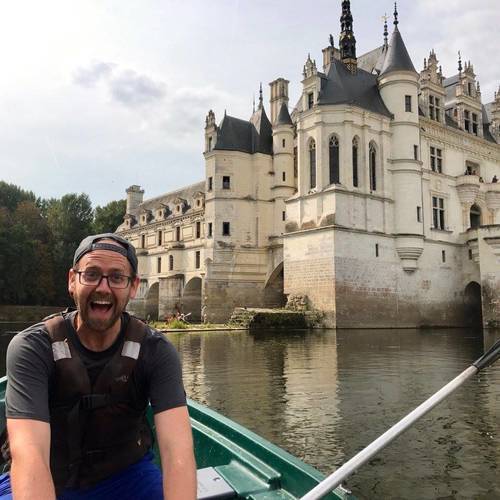 Nicholas Norris in a boat in front of a castle